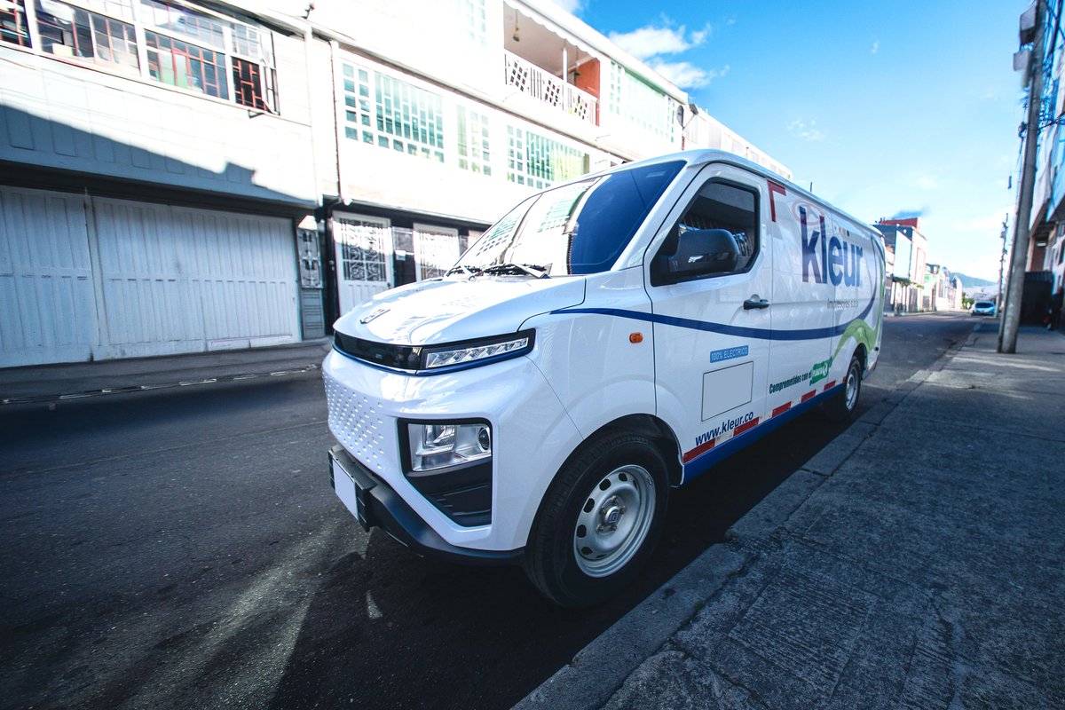 Van eléctrica de Farizon rotulada con la marca Kleur Impresores circulando por una calle de Bogotá