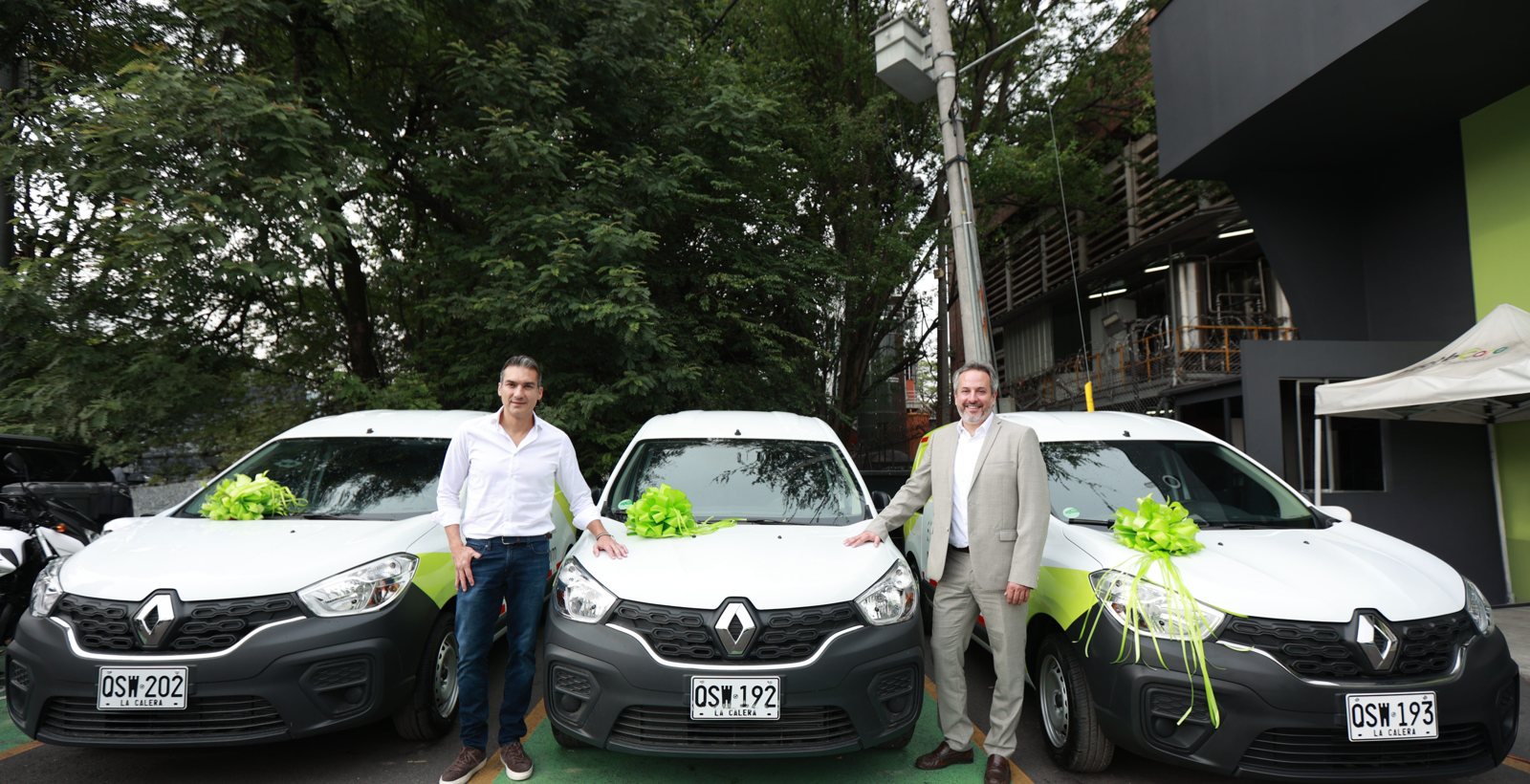 Tres Renault Kangoo con lazos verdes junto a ejecutivos de Renault y Haceb
